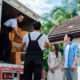 Side view of movers helping couple with move in process, moving boxes off truck