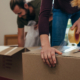Close up of a woman applying adhesive tape on a packing box