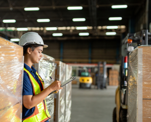 Worker walking past boxes in warehouse_