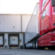 Red modern American semi truck parked at the docks